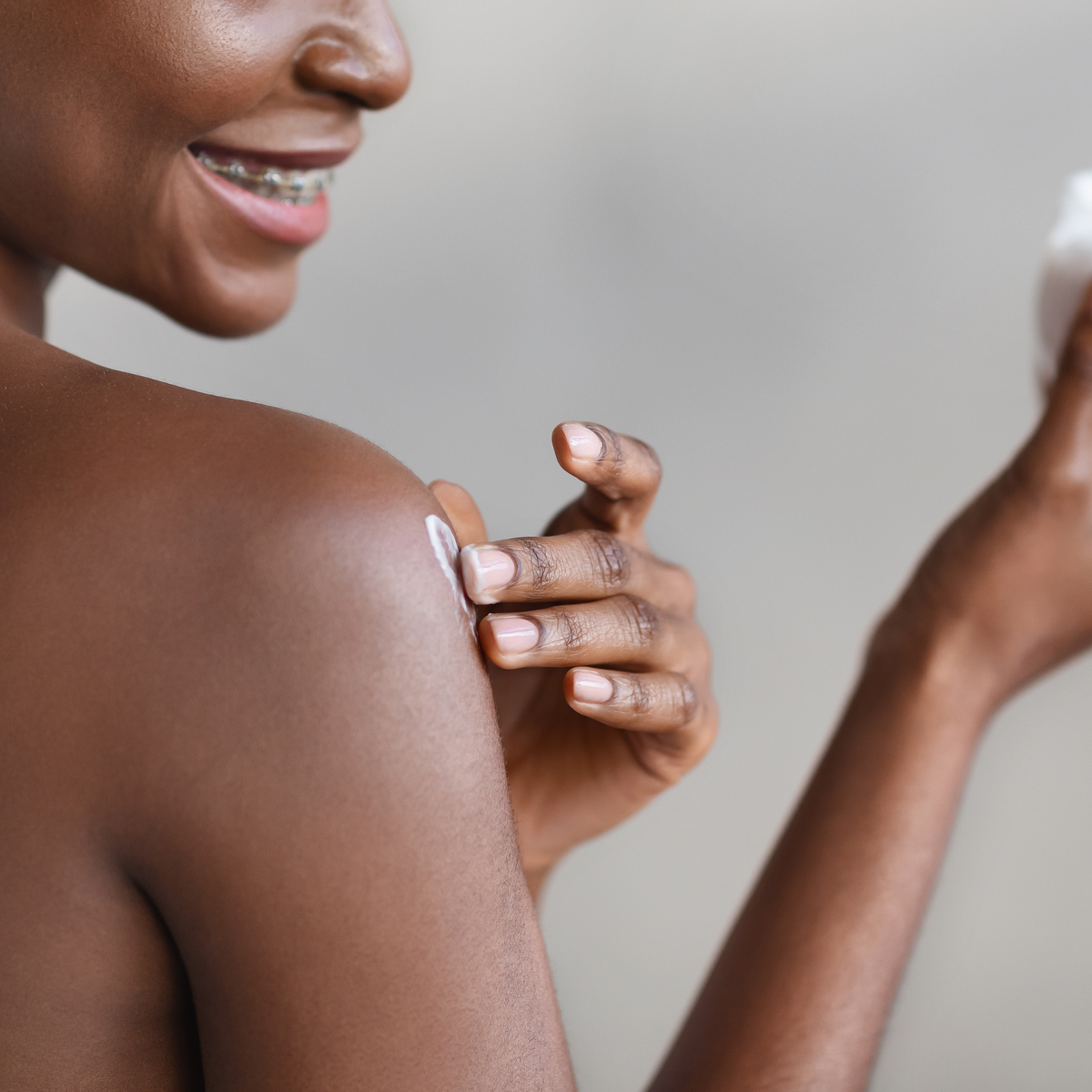 A woman applying body butter to her arm.